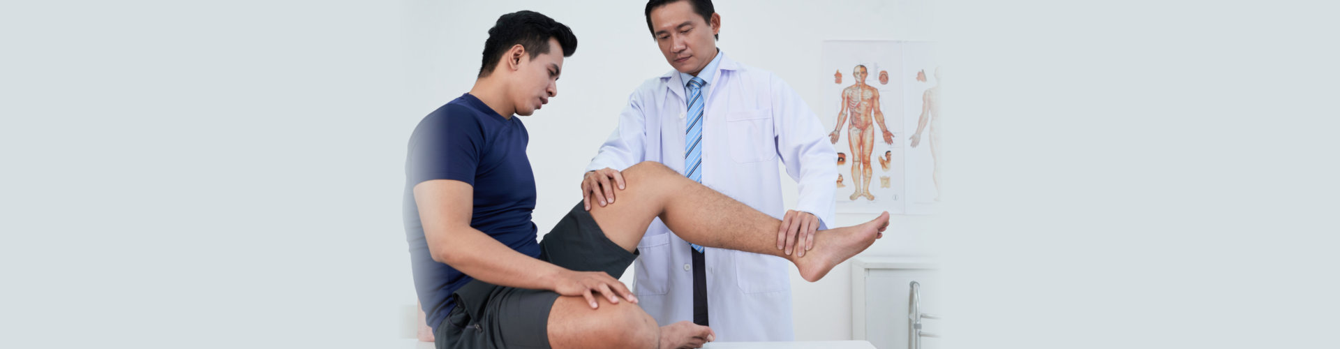 Physiotherapist examining young sportsman with trauma of leg